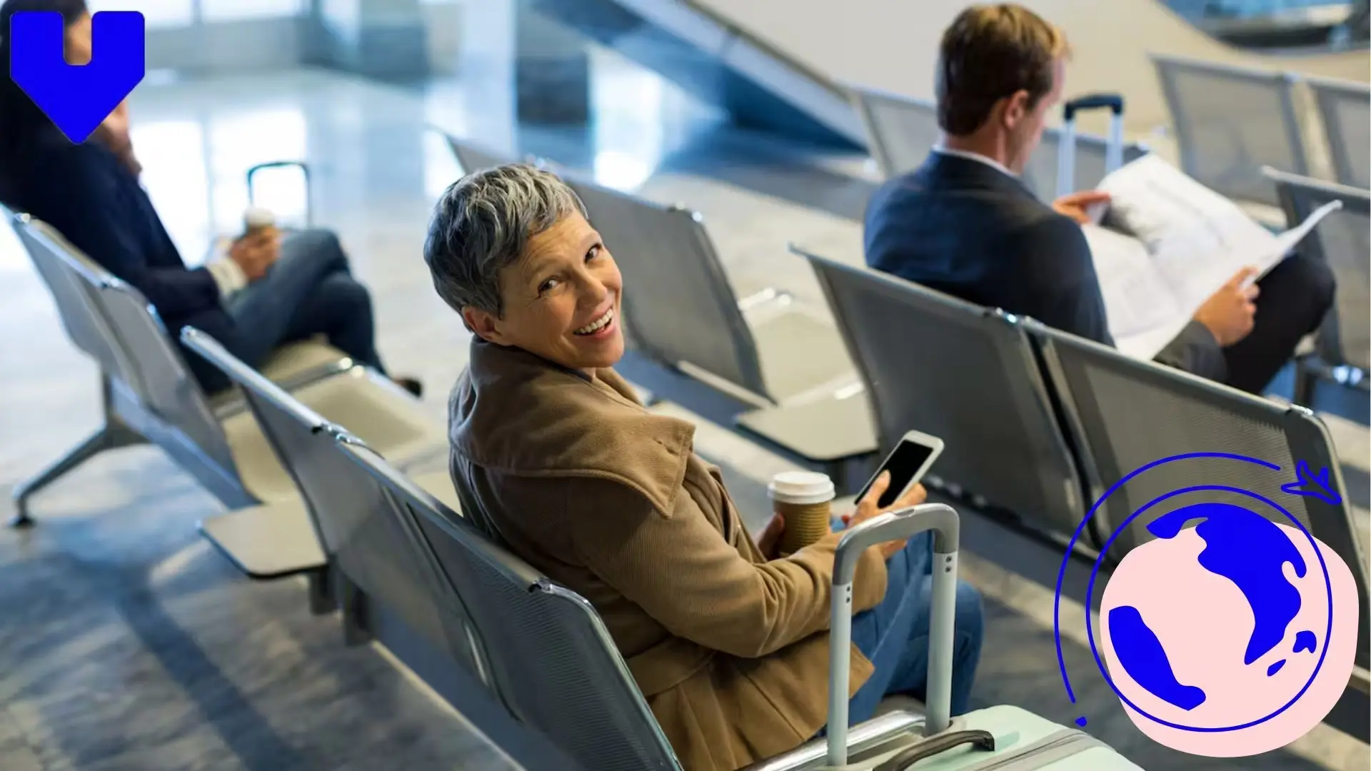 Traveler waiting at an airport with luggage and smartphone