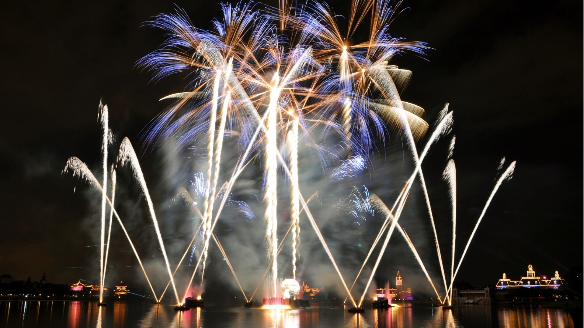 Illuminated amusement park at night showcasing global theme park attractions