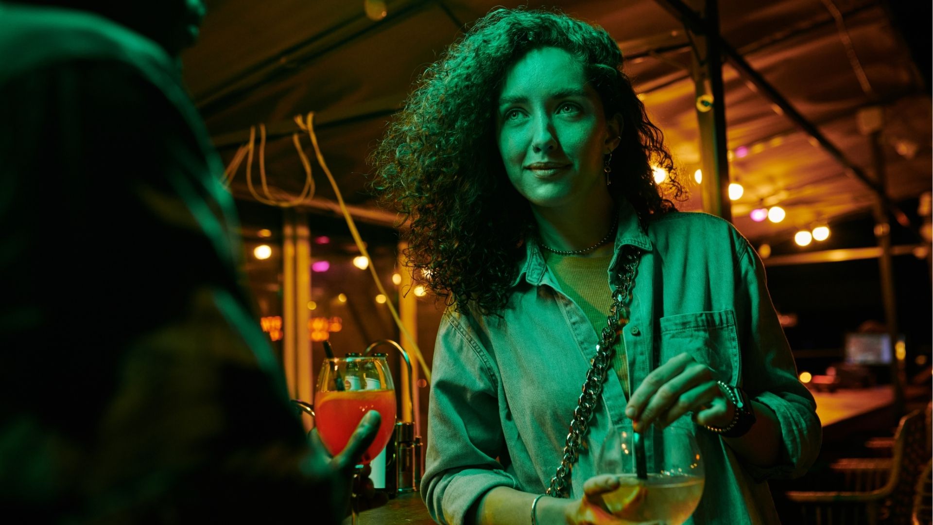 Woman enjoying drinks at a dimly lit rooftop bar