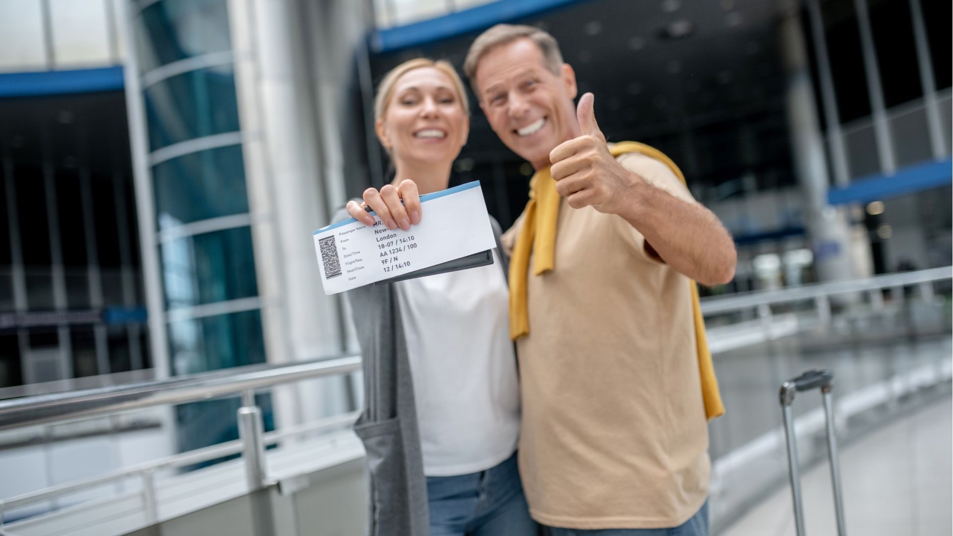 Happy couple at airport with boarding passes