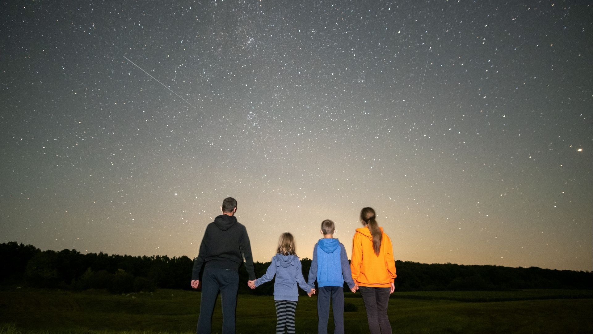 Family observing starry night sky
