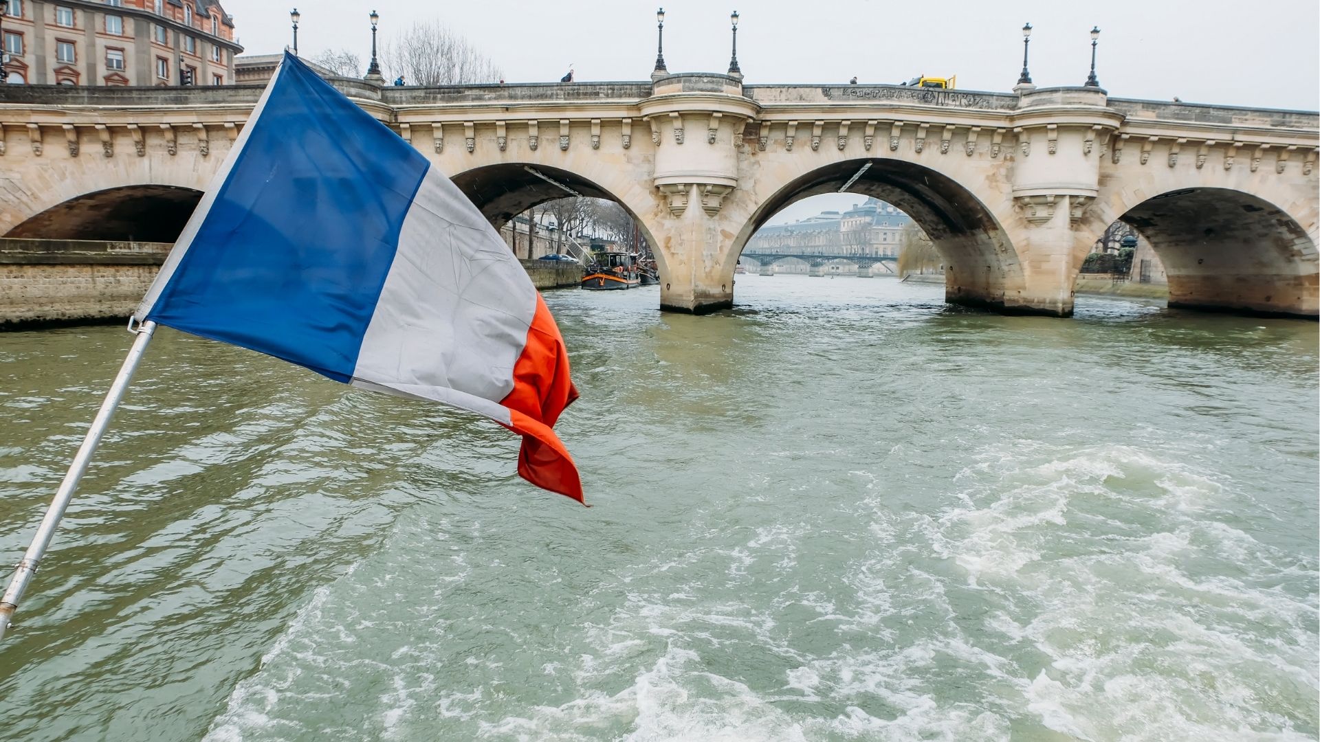 Seine River scene with French flag and classic Paris architecture