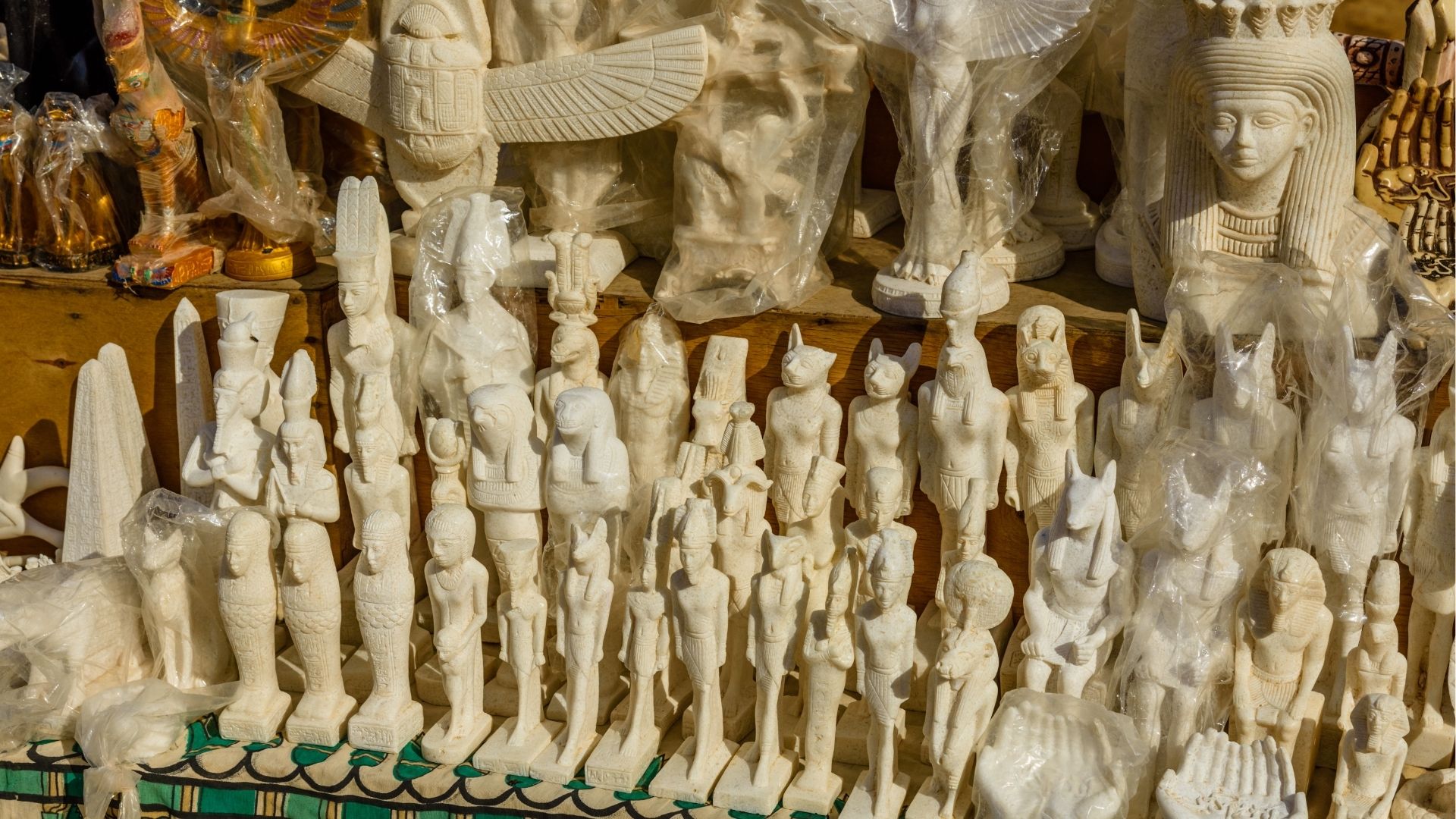 Egyptian stone statues and souvenirs at a market.