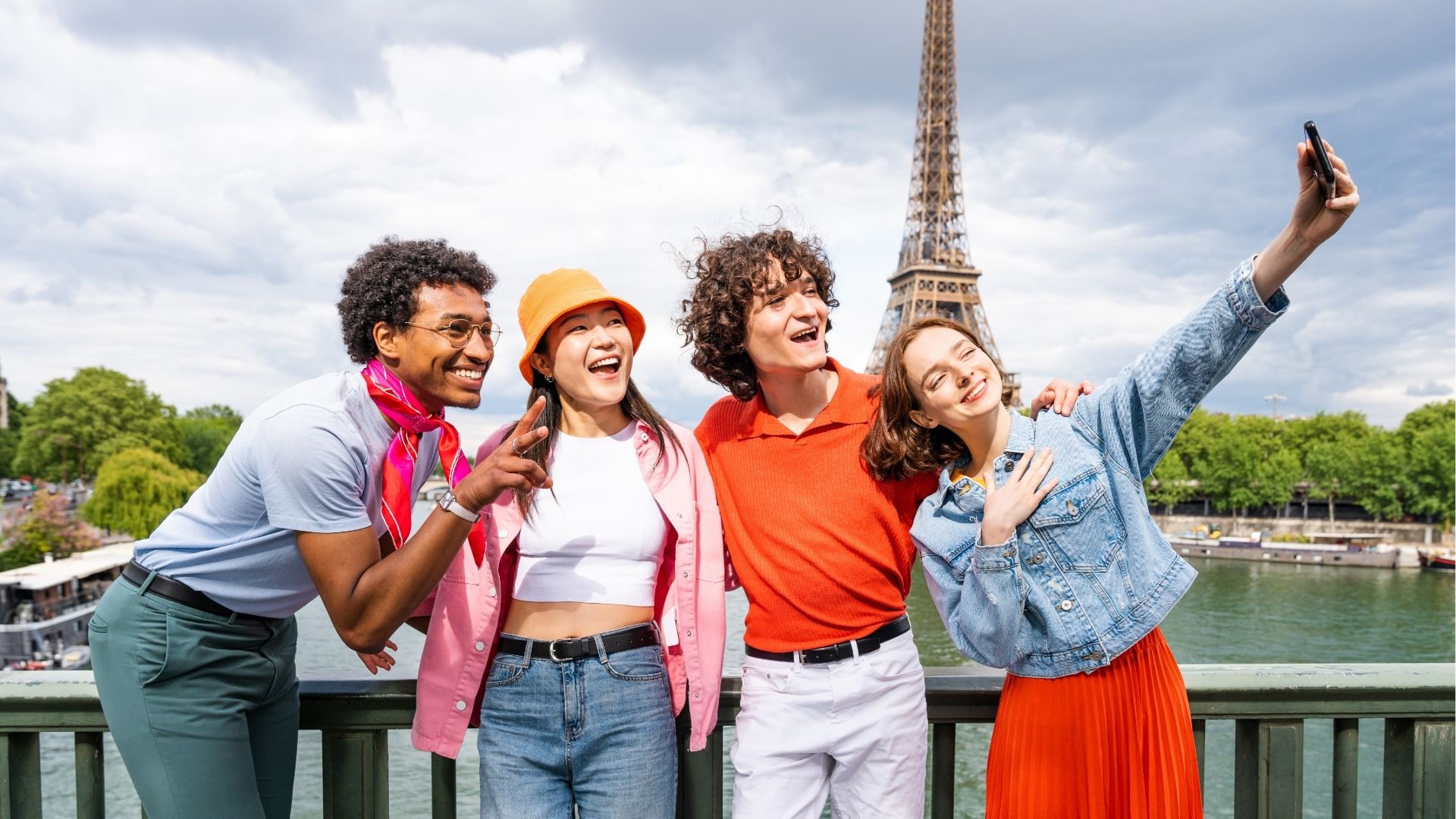 Group of young happy friends visiting Paris and Eiffel Tower
