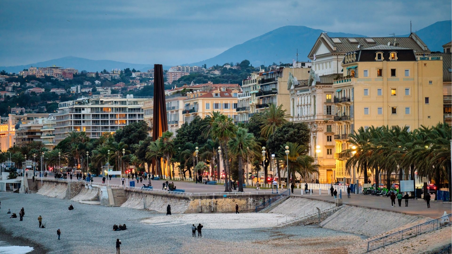 Nice city promenade in the evening at blue hour, buildings with mountains