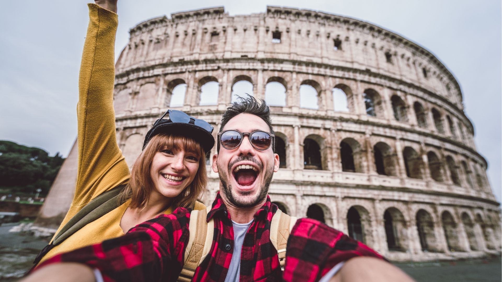 Friends taking a selfie in front of the Colosseum in Rome, Italy