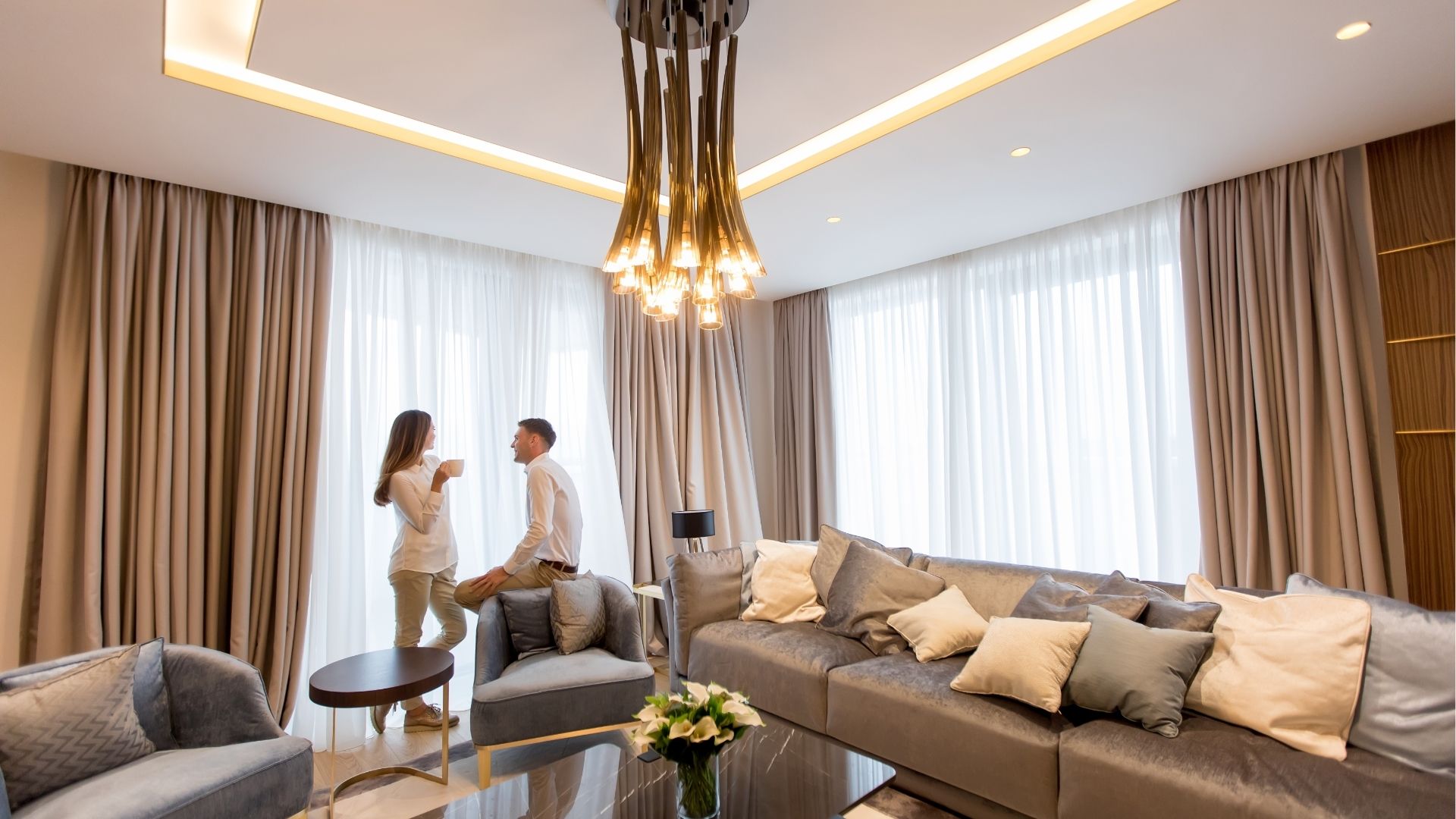 Young couple relaxing and talking with coffee cups in the luxurious room