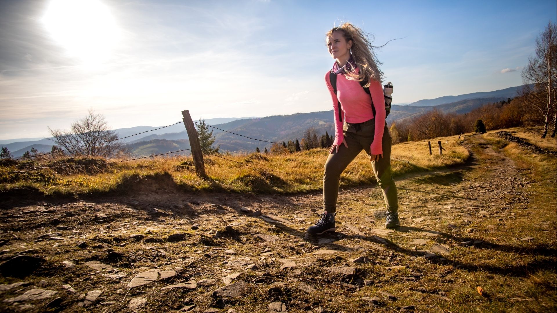 Hiker young woman with backpack rises to the mountain