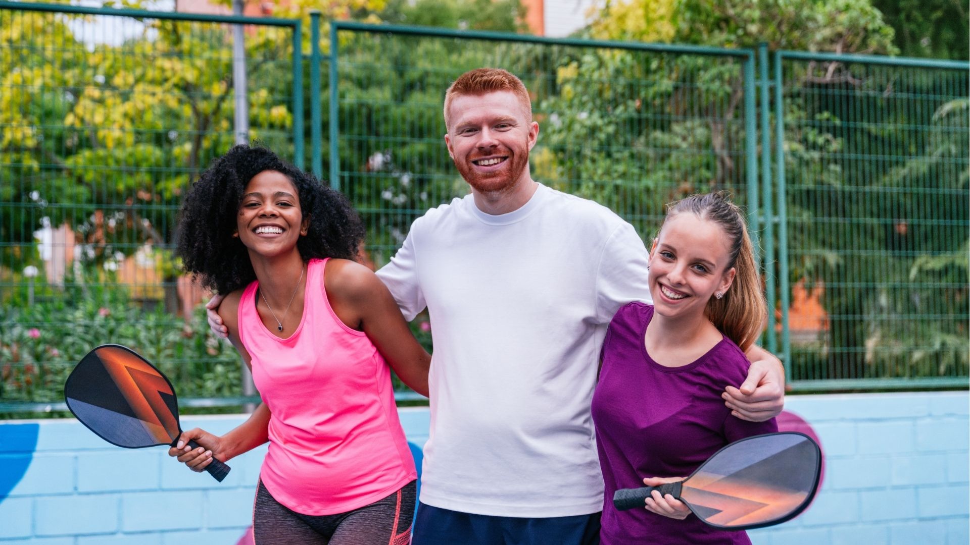 Multiethnic friends enjoying pickleball together on court