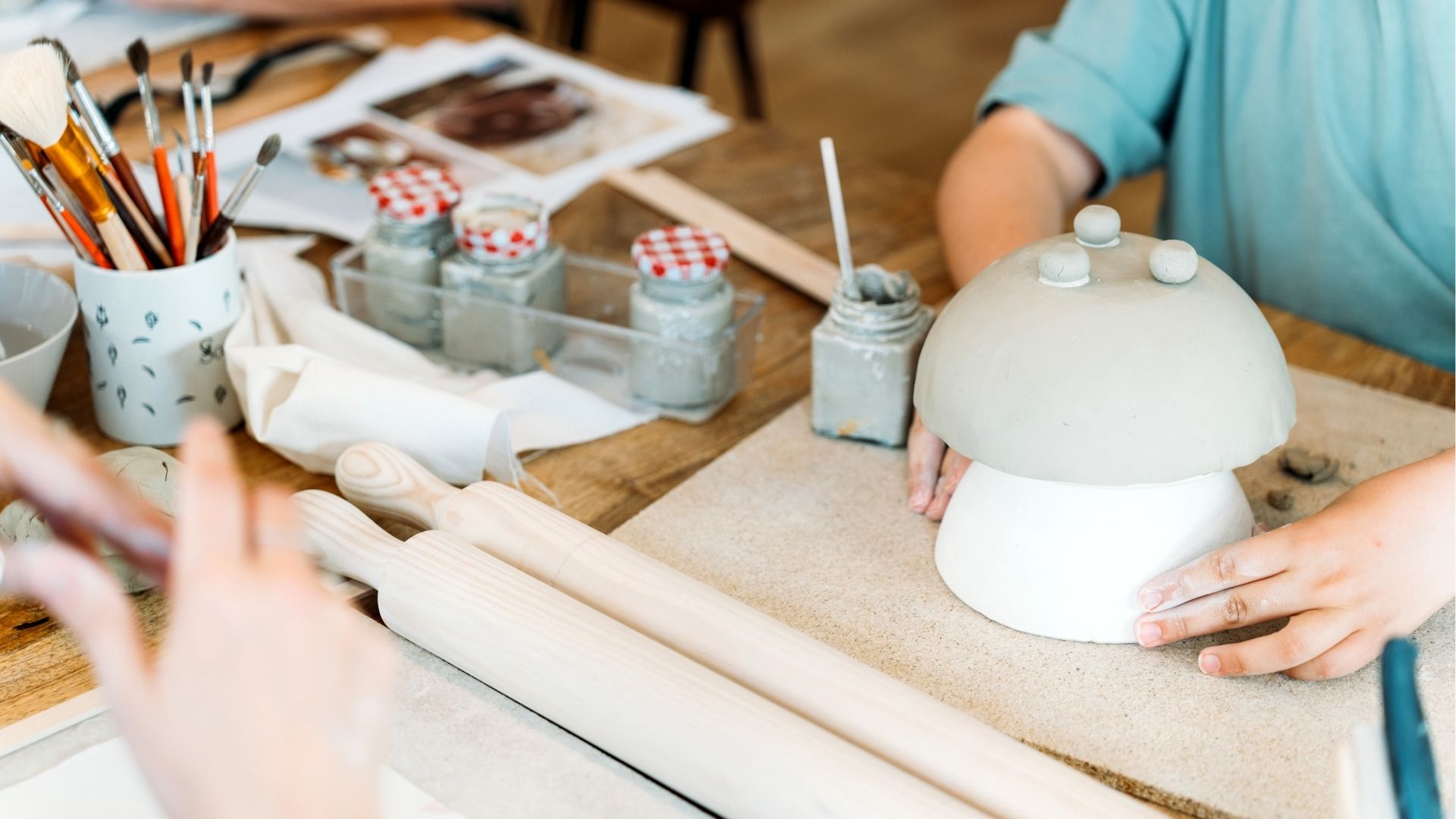Ceramic workshop. Group of friends crafting a ceramic plate