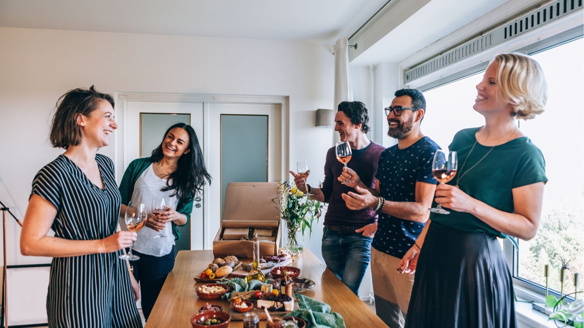 Happy friends laugh with a glass of wine in hand