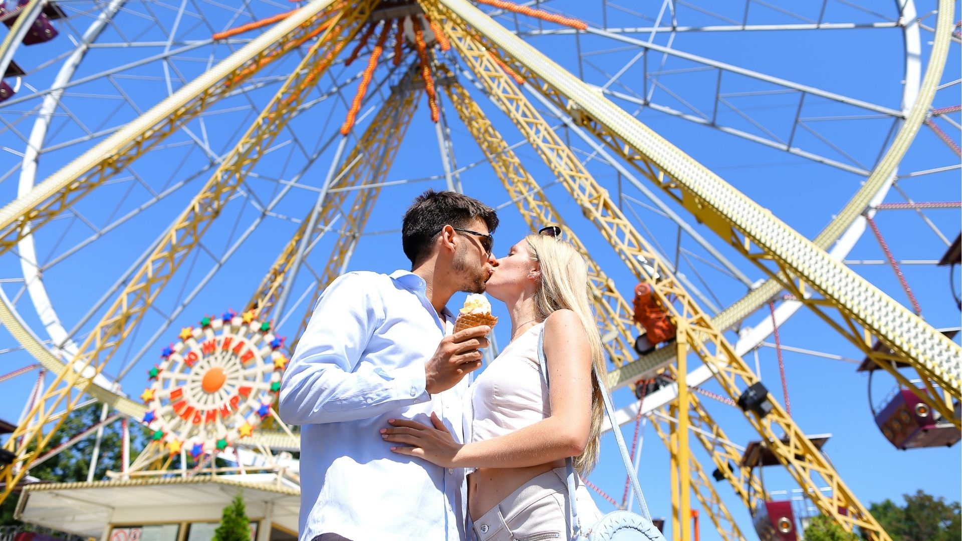 Cute young couple kissing, hugging, and smiling while looking into each other’s eyes