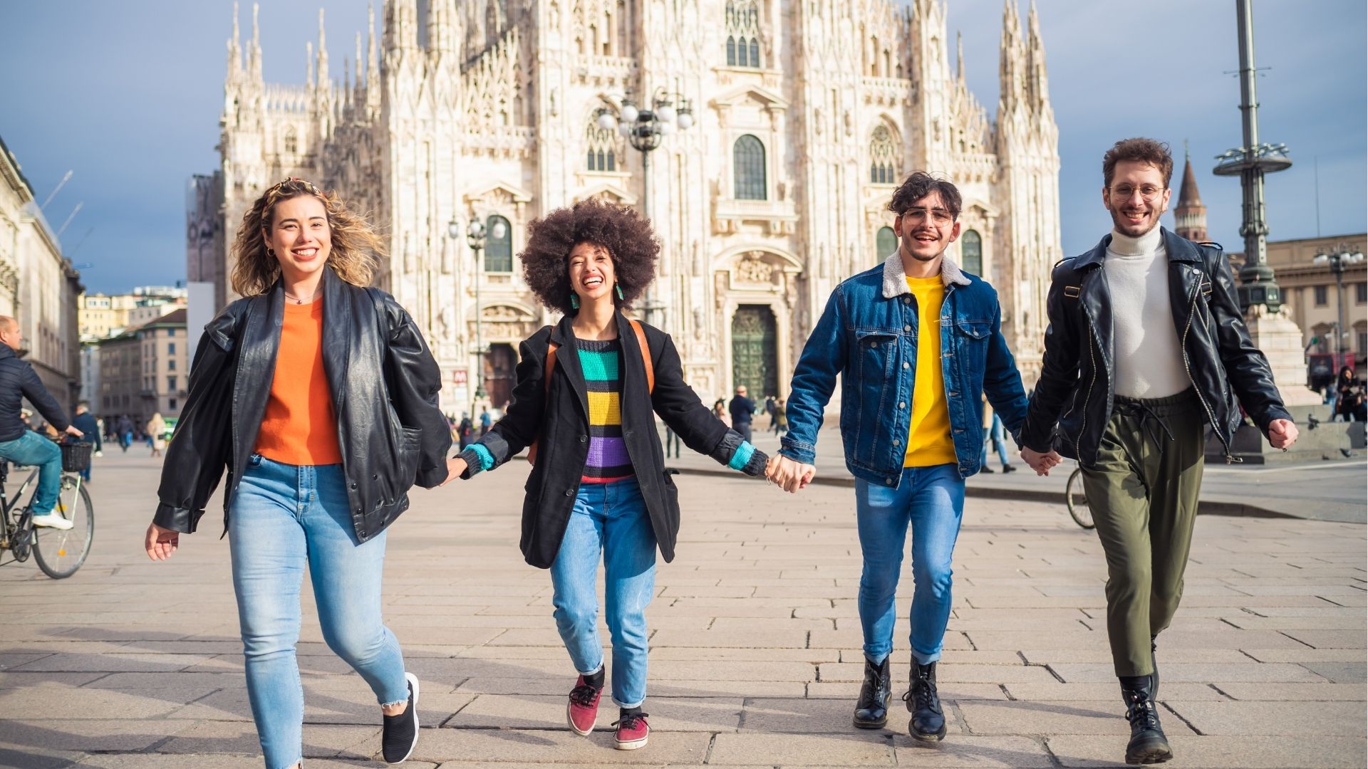 Group of friends running in Duomo Square in Milan, celebrating and laughing