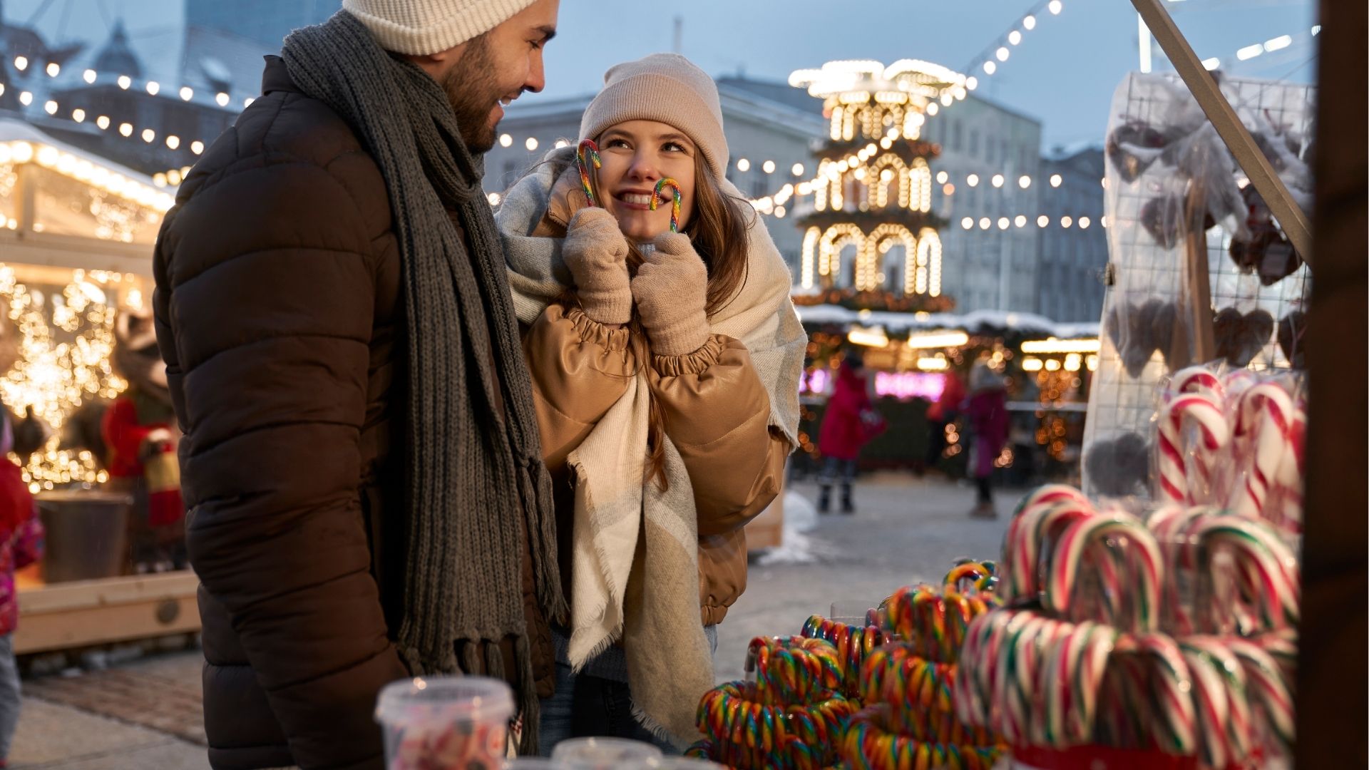 Couple buying candies on Christmas market at night
