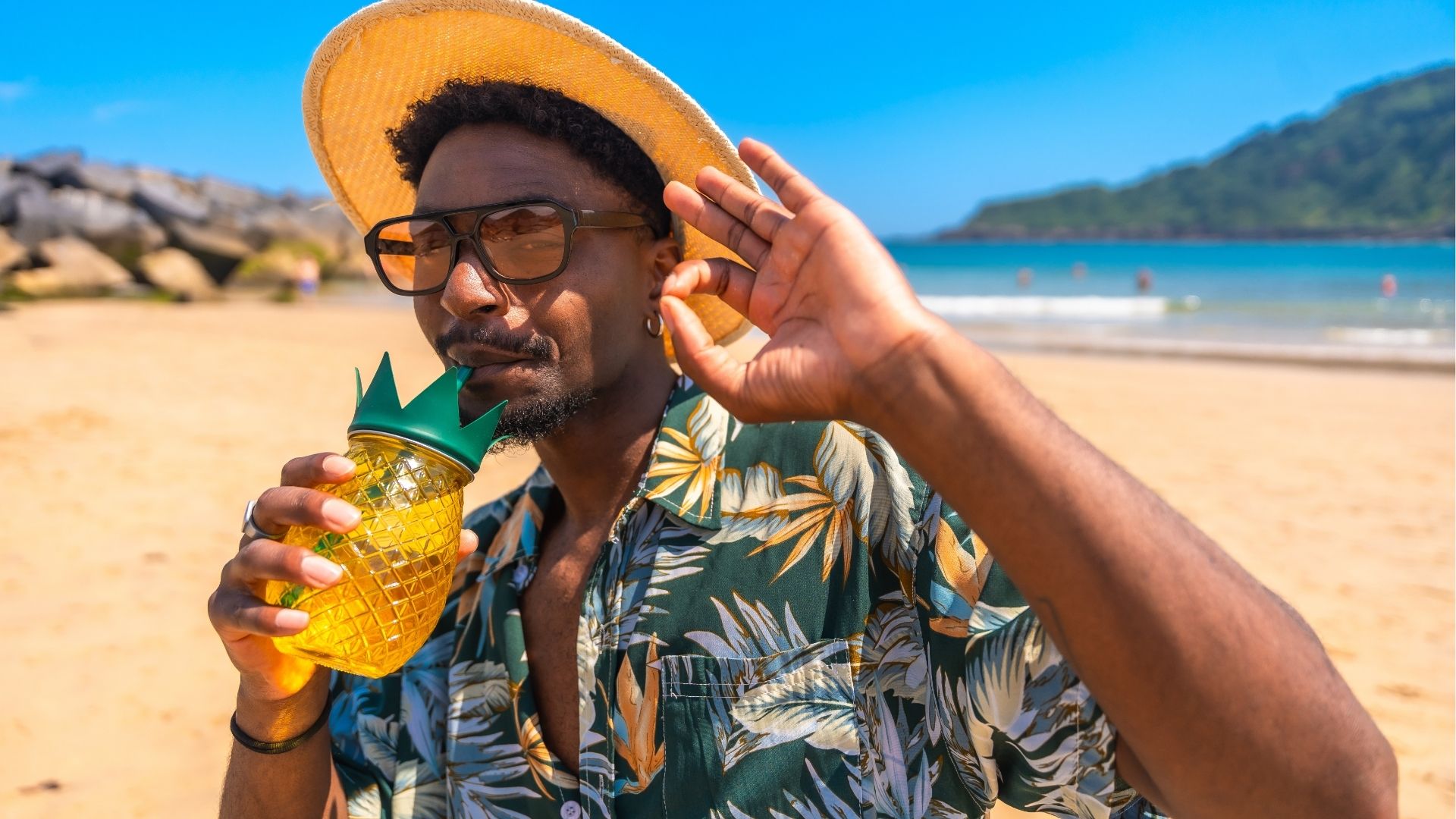 Tourist enjoying a refreshing pineapple cocktail on a tropical beach
