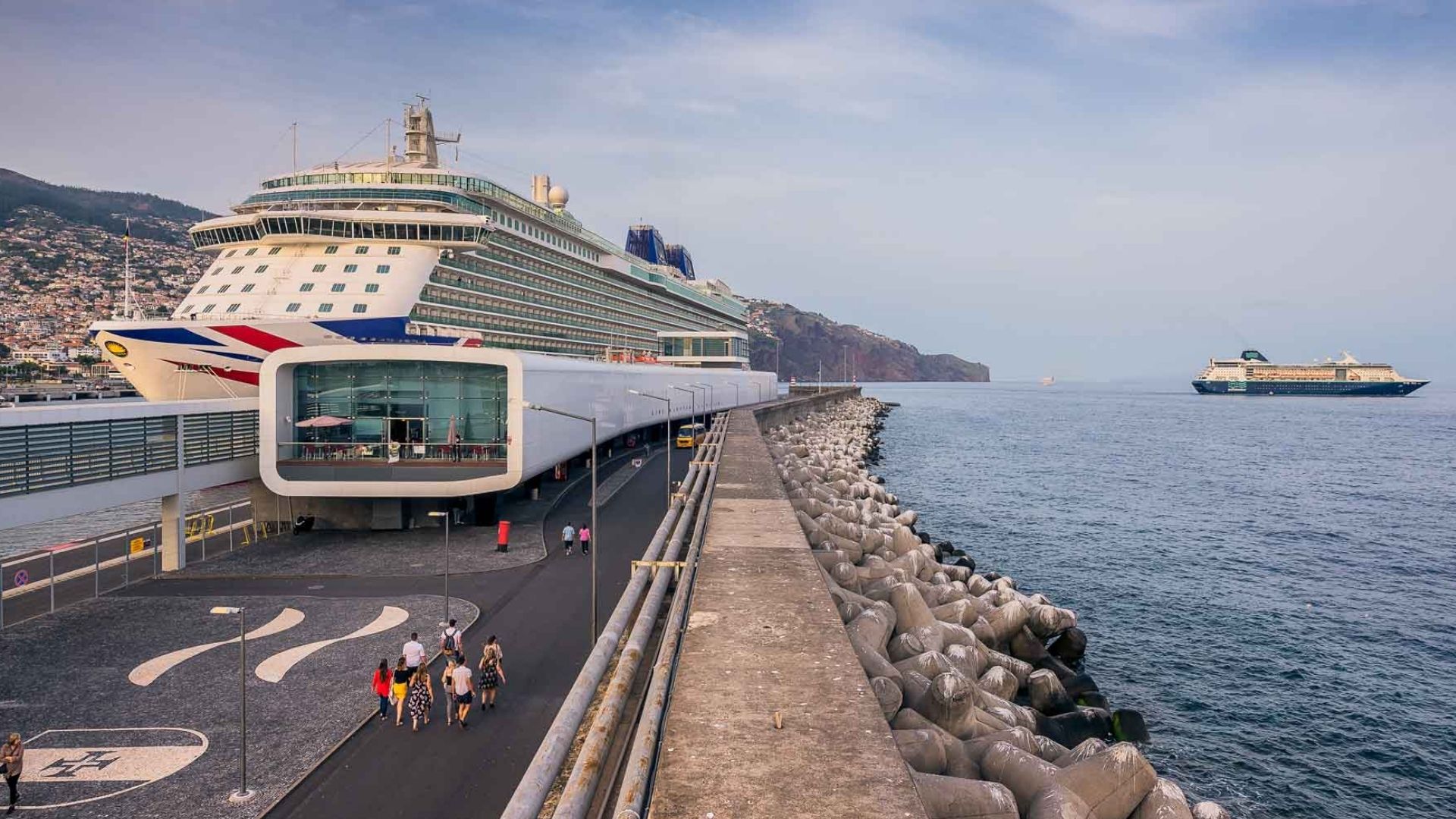 Travelers walking near a cruise ship at the harbor