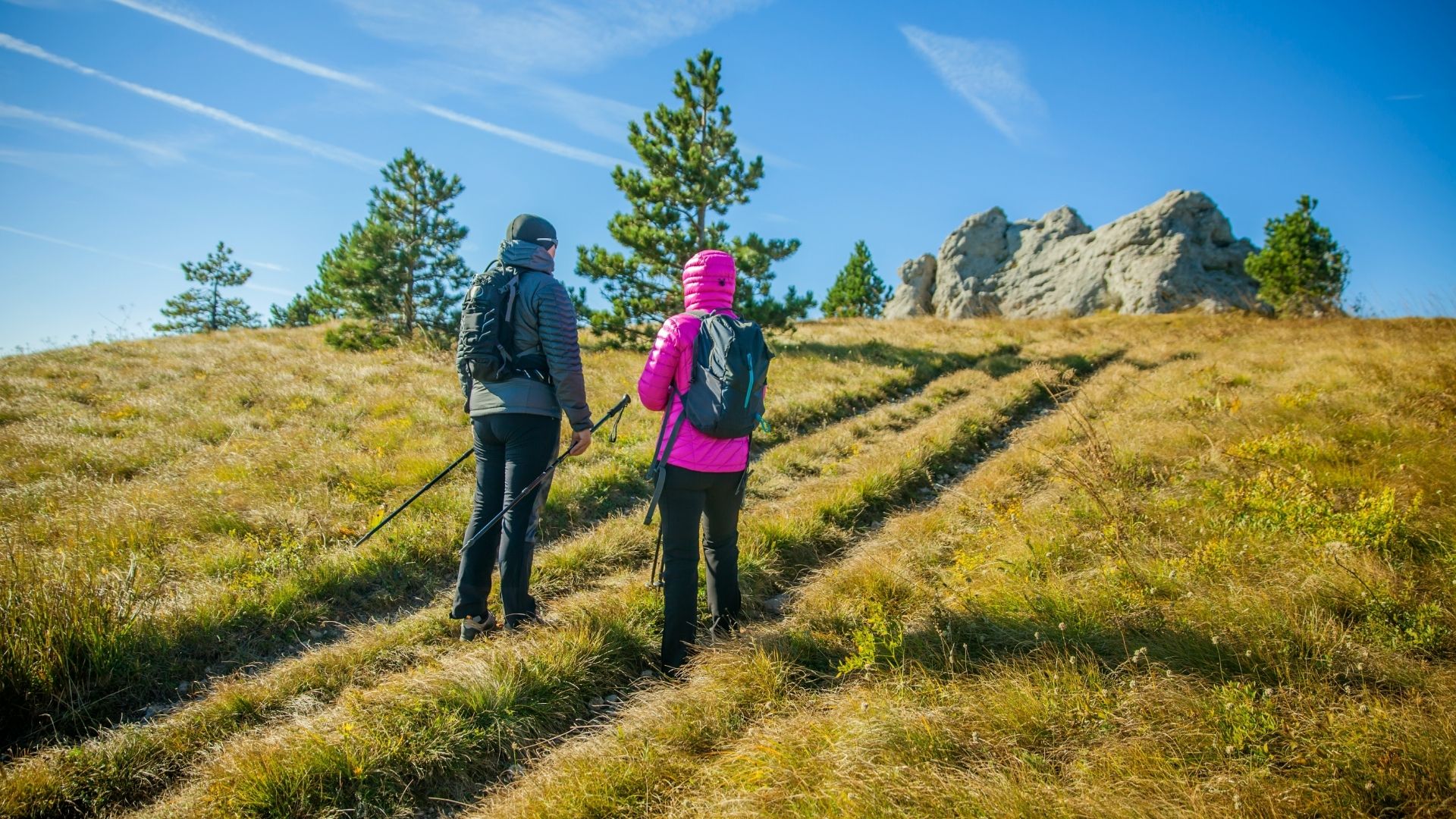 A Lovely Tourist Couple Climbing The Slovenian Rocky Mountains Under The Blue Sky
