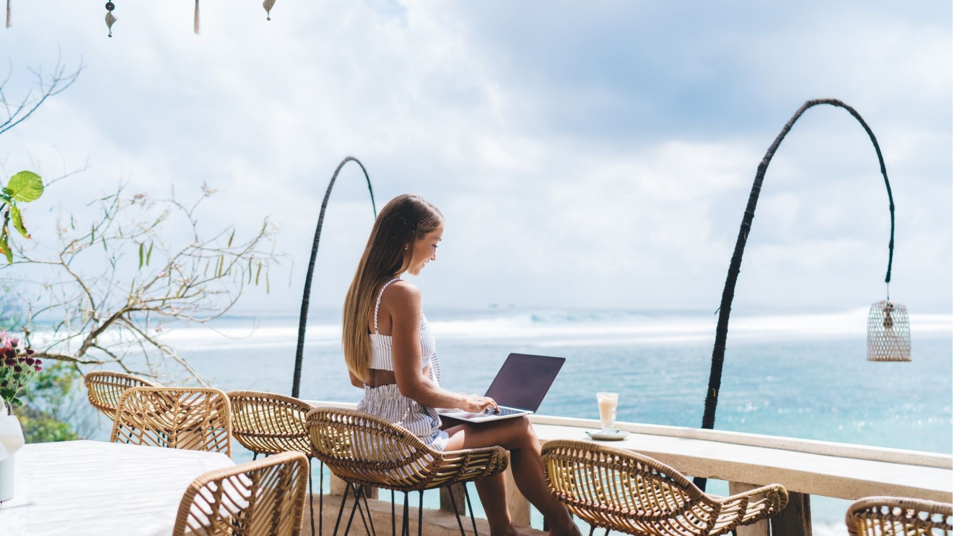 Woman working on laptop on terrace during vacation
