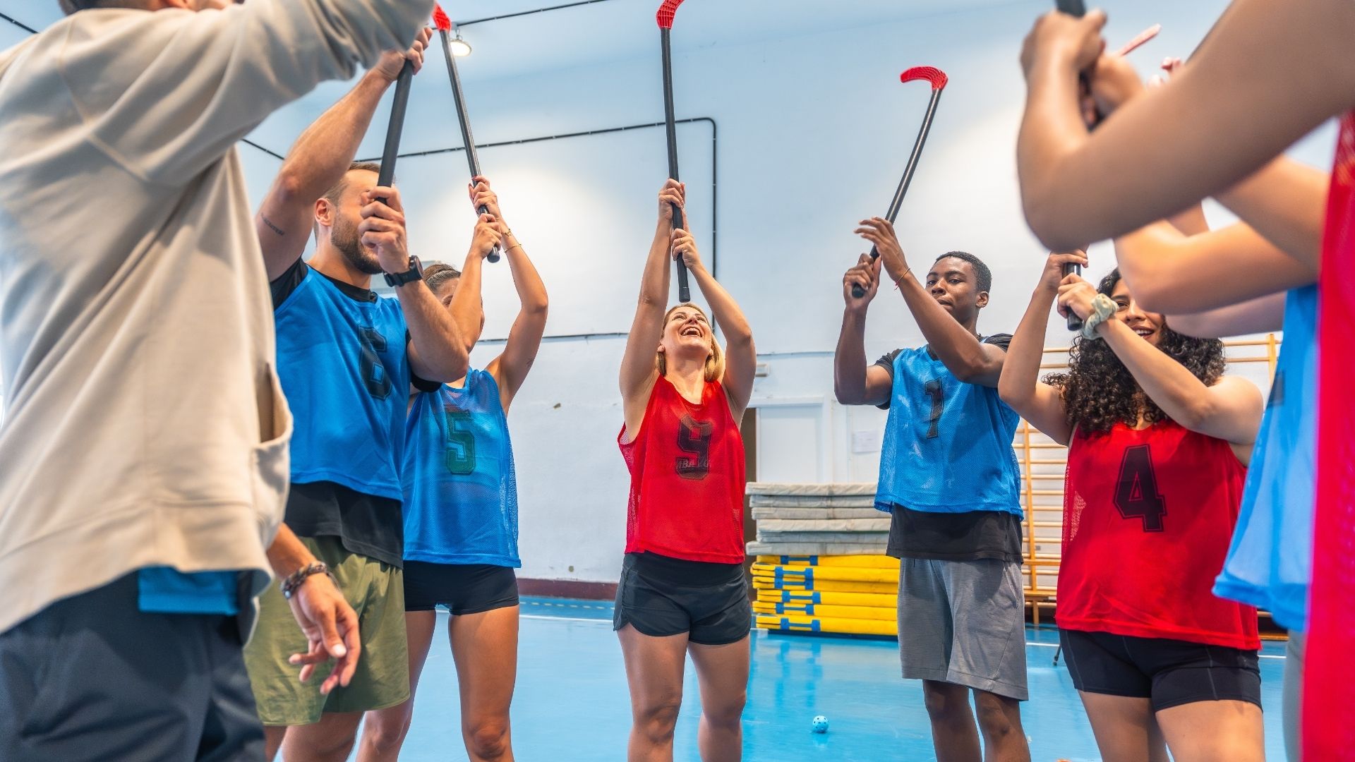 Hockey players raising sticks together in celebration
