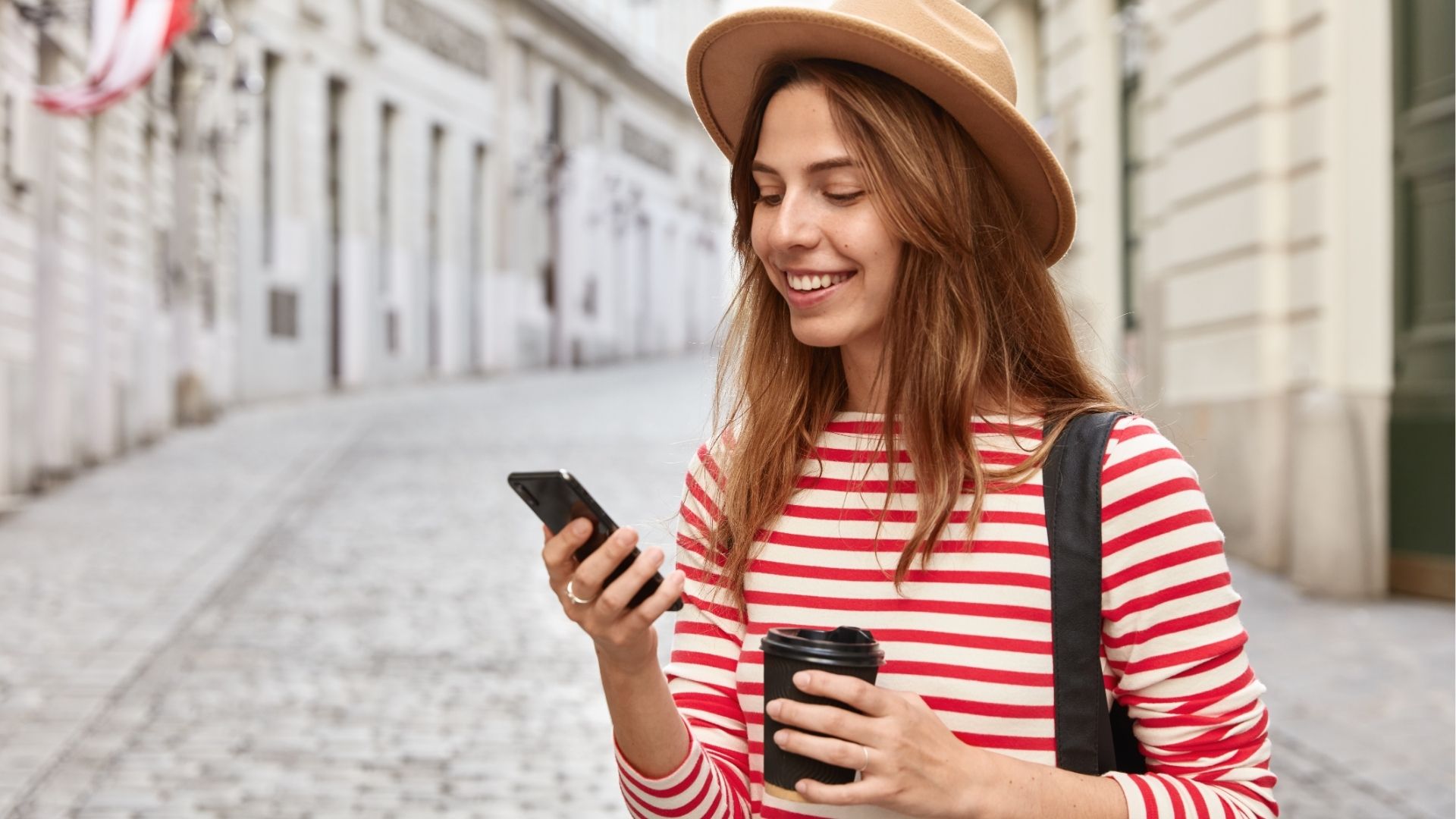 Tourist strolls on city streets, uses online navigator for finding right way, holding cell phone