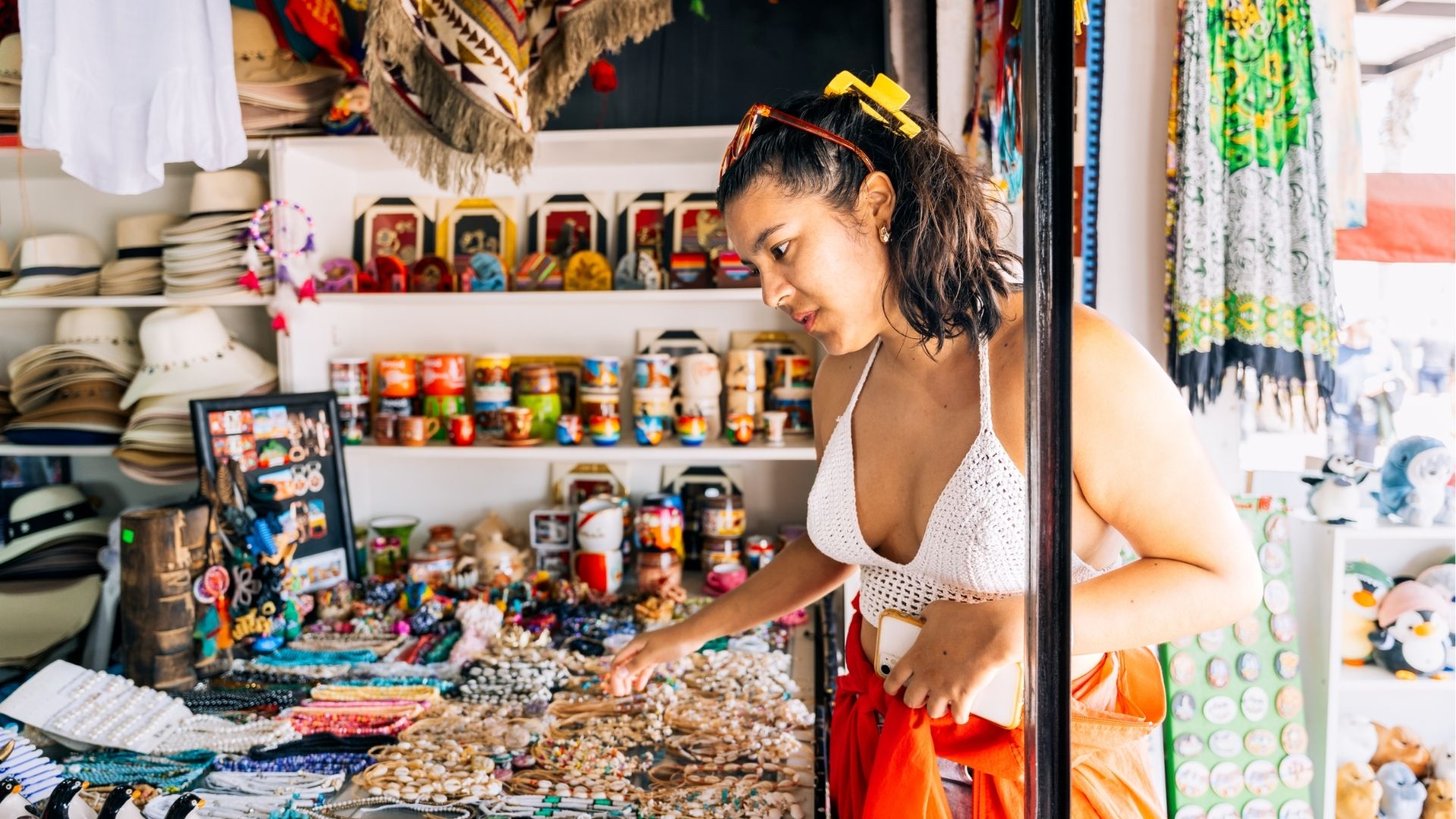 Young woman shopping for handmade jewelry at craft market