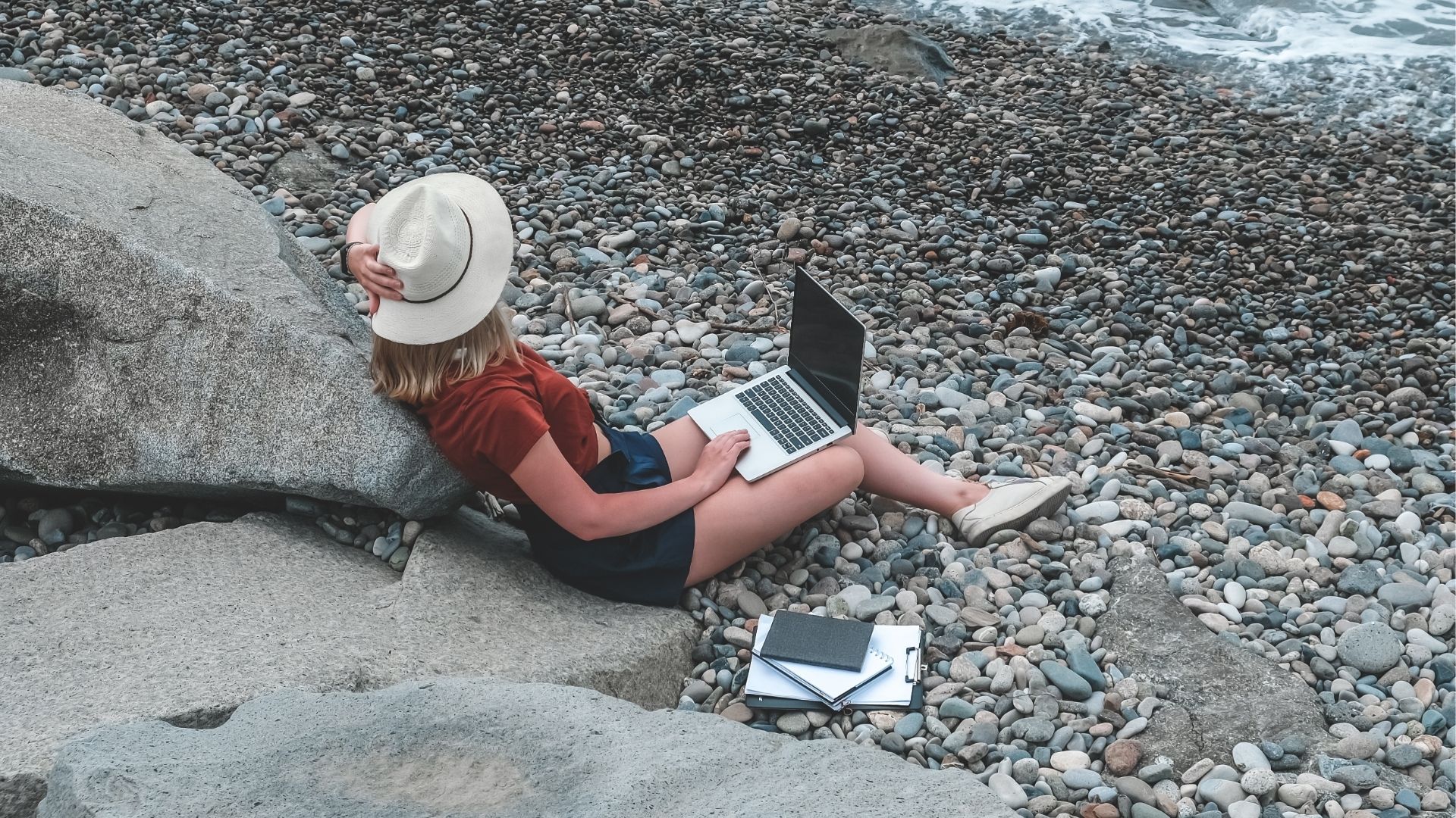 Freelancer works remotely on the seashore, Workation