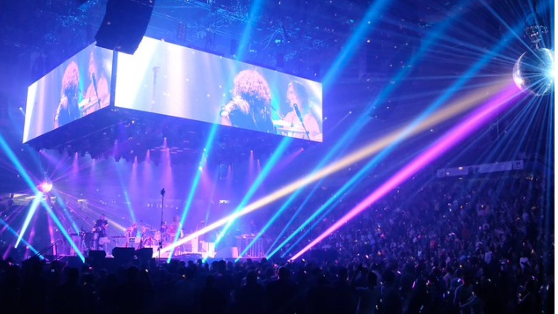 EDM festival stage with lasers and energetic audience in Vancouver arena