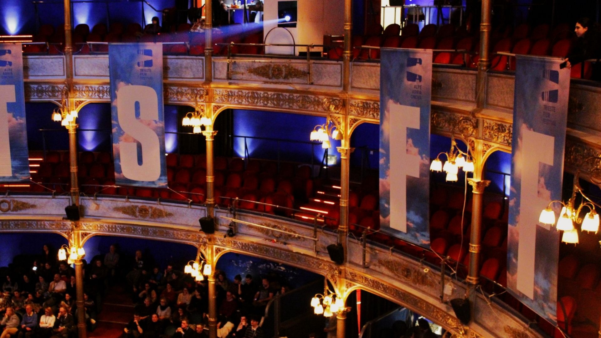 Interior of Trieste Film Festival screening venue with audience and film banners 