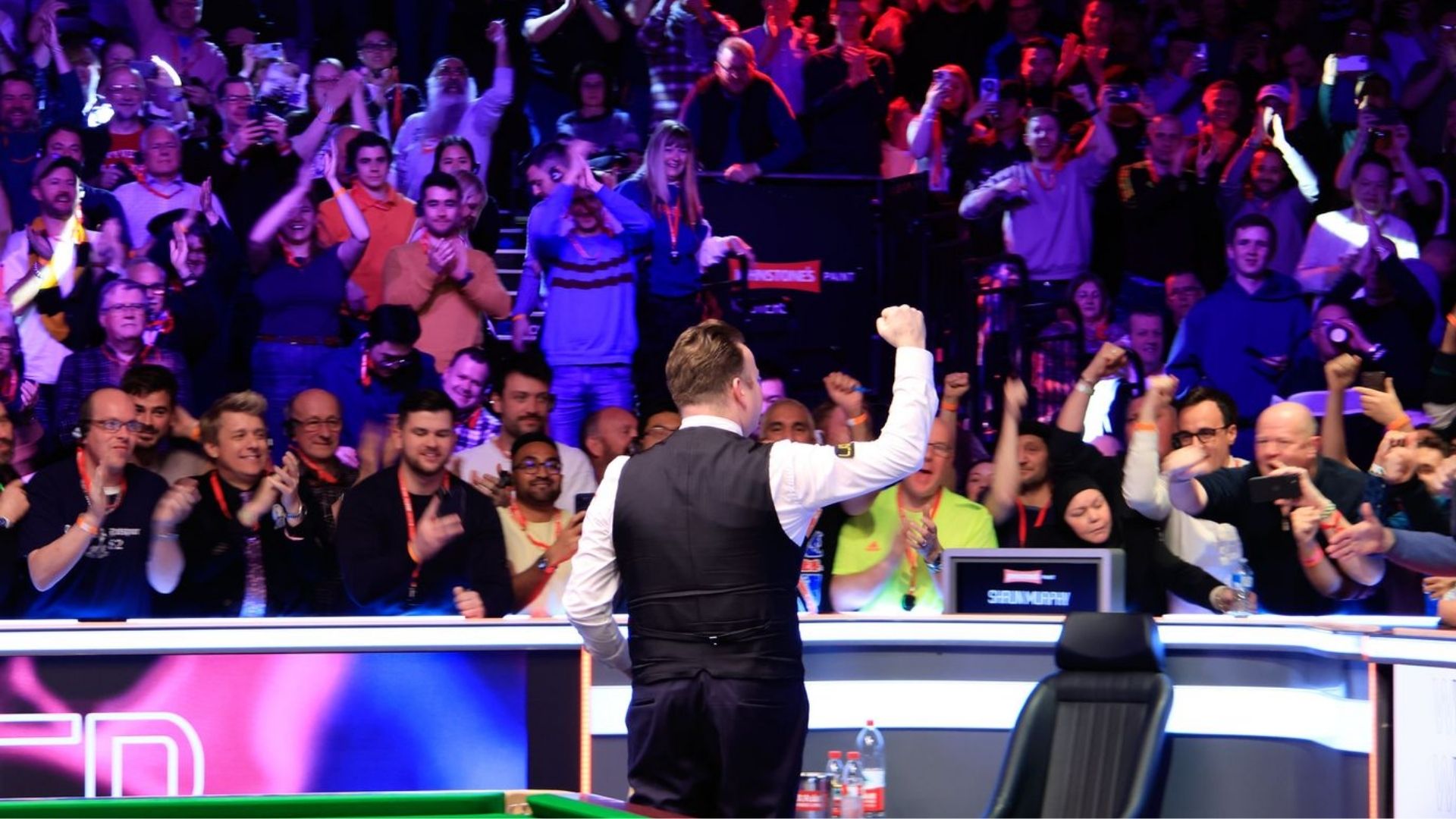 Crowd cheering as a professional snooker player raises his fist during a match at Alexandra Palace