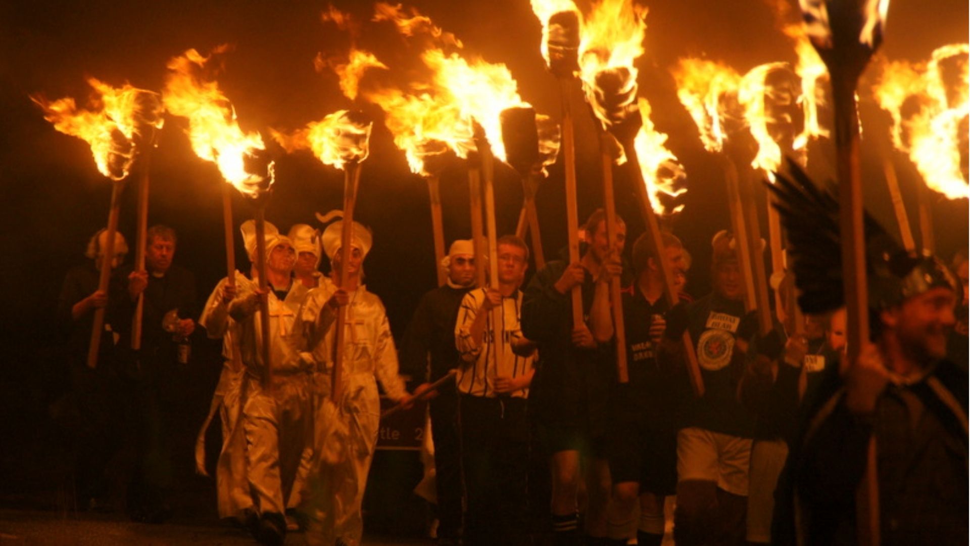 Torchbearers marching at night during the Up Helly Aa procession