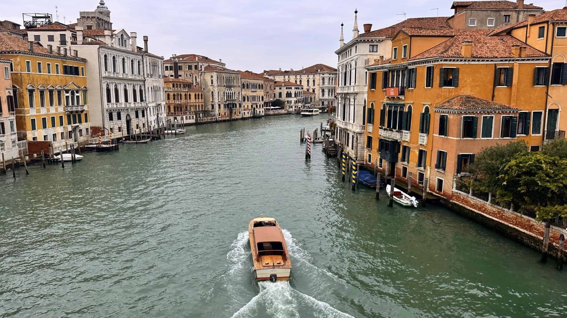 Venice canal with historic buildings and a boat moving through calm waters during winter in Europe