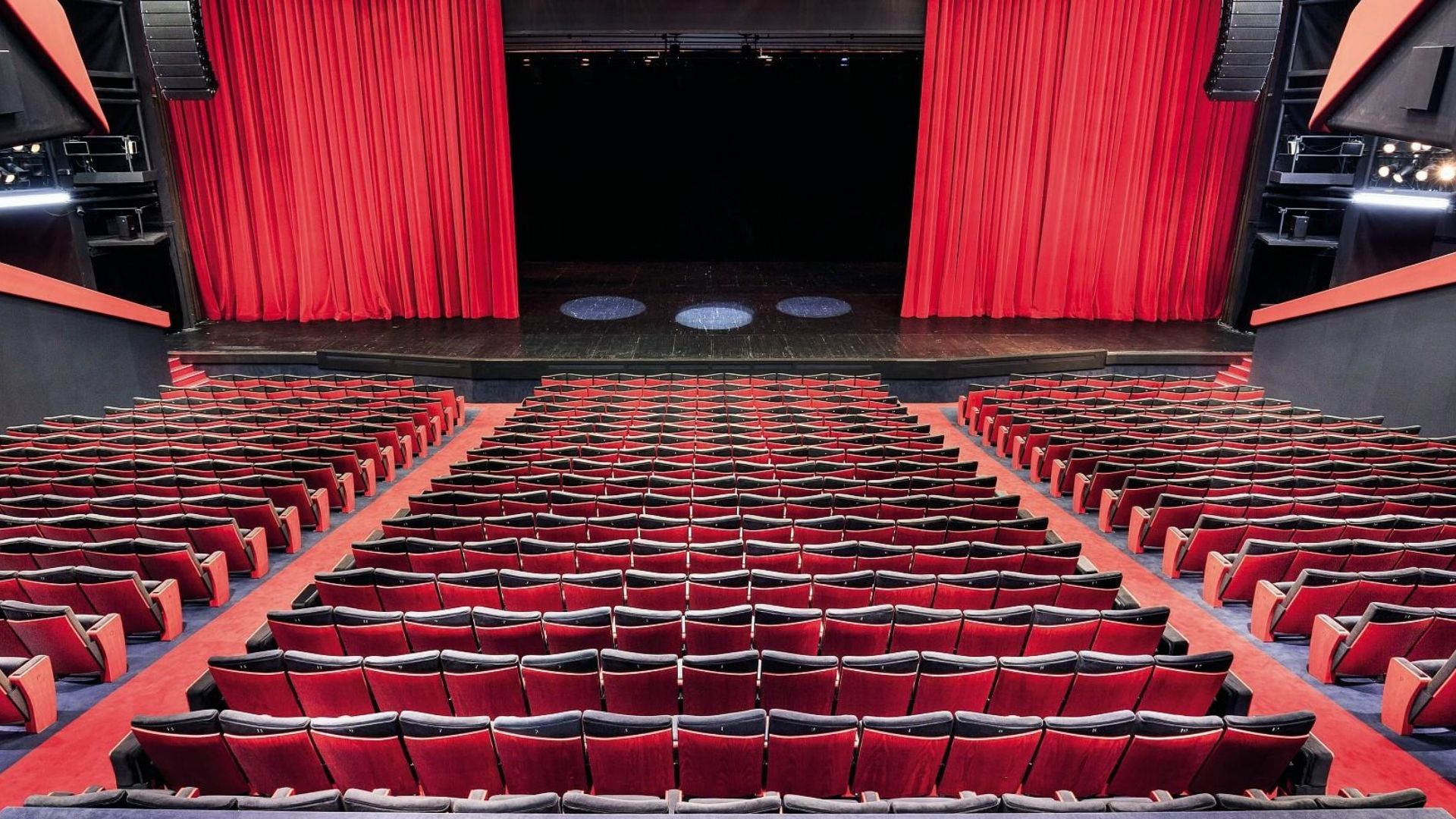 Interior theatre hall at Cannes Film Festival screening venue with red seats and stage
