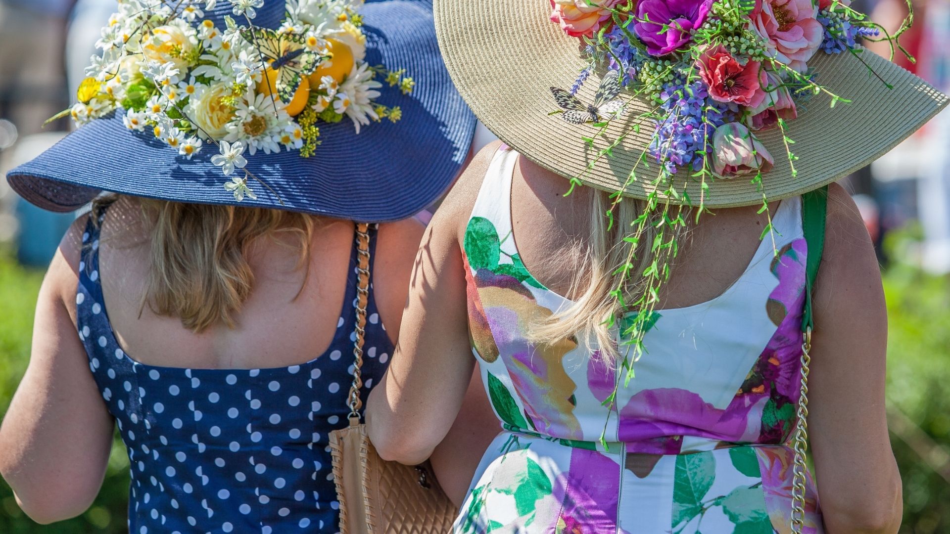 Women in Floral Hats Attending an Outdoor Event
