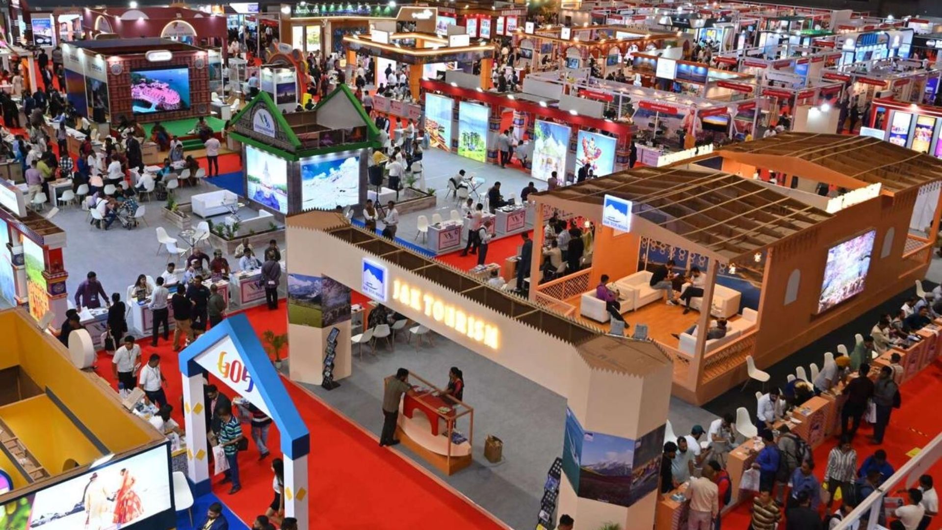 Tourism trade show in India with multiple destination displays and crowds