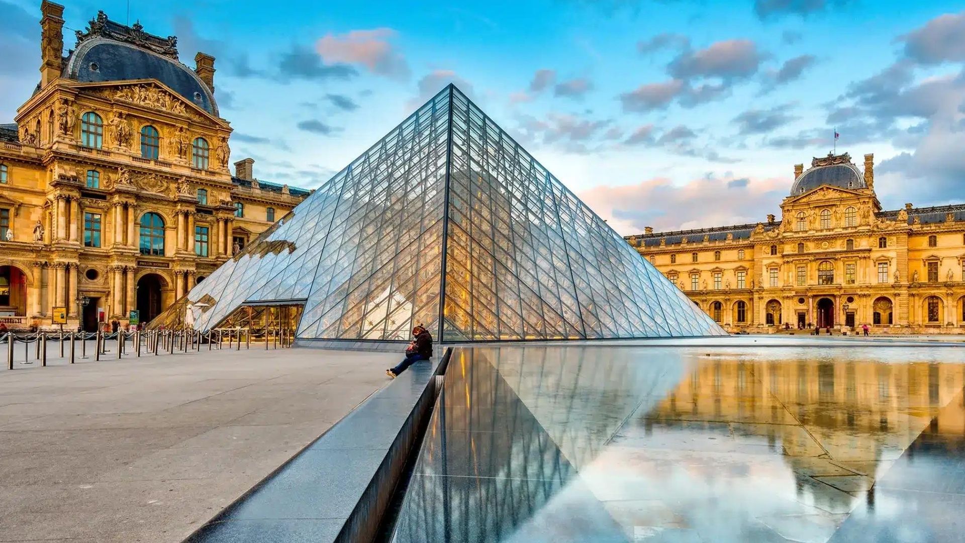 Louvre Museum glass pyramid courtyard in Paris with historic architecture